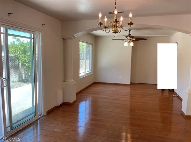 a view of a room with wooden flooring and chandelier
