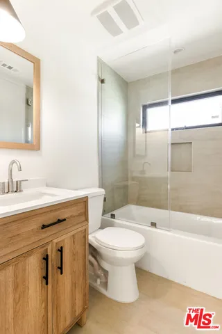 a bathroom with a sink toilet vanity and shower