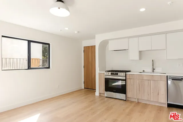 a kitchen with white cabinets and stainless steel appliances