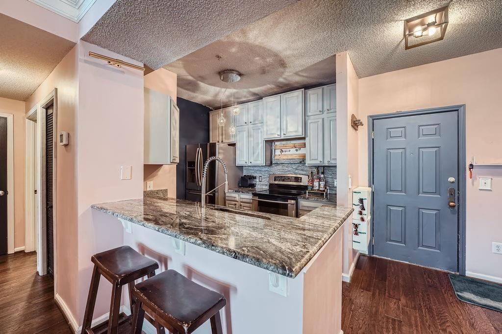 955 Juniper Street Northeast, Unit 4127 Atlanta, GA 30309 - Photo 9 of 29 a kitchen with stainless steel appliances granite countertop a sink refrigerator and microwave