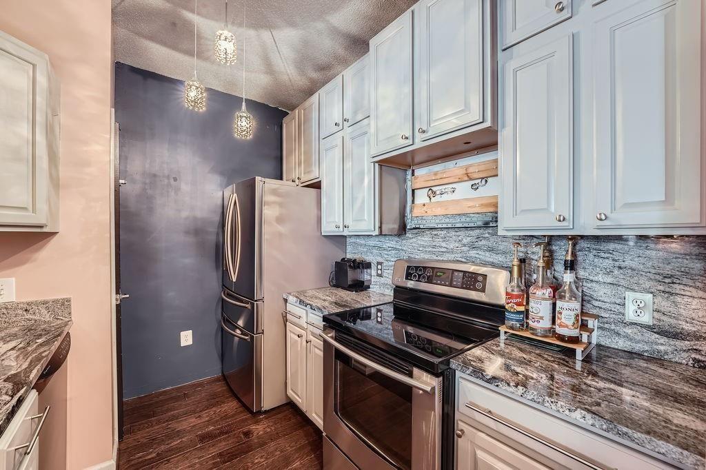 955 Juniper Street Northeast, Unit 4127 Atlanta, GA 30309 - Photo 10 of 29 a kitchen with stainless steel appliances granite countertop a refrigerator stove and cabinets