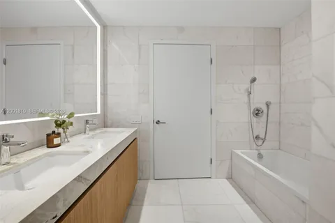 a spacious bathroom with a tub sink and mirror
