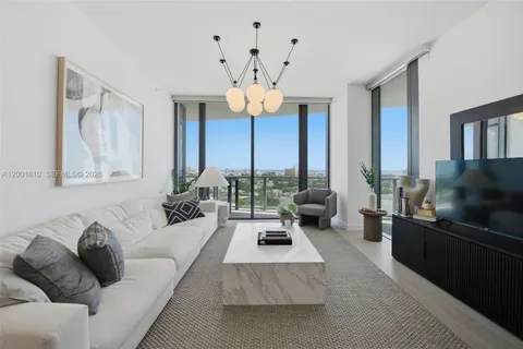 a living room with furniture a chandelier and a flat screen tv