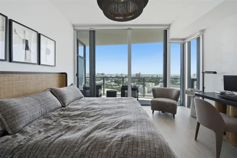 a bedroom with a large bed and a large window