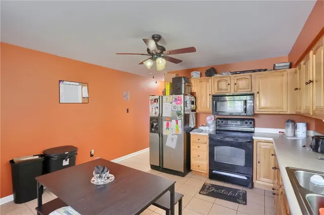 a kitchen with stainless steel appliances kitchen island granite countertop a refrigerator a stove a microwave oven with a dining table and chairs