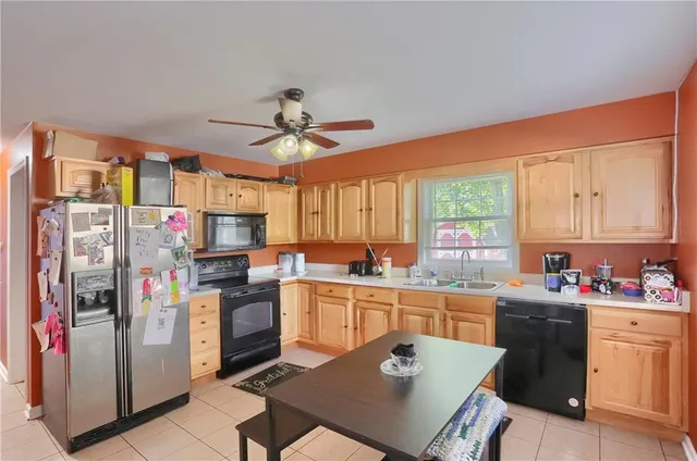 a kitchen with a sink a stove a refrigerator and cabinetry