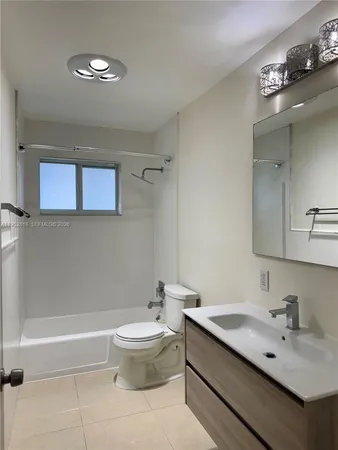 a bathroom with a bathtub shower sink vanity and toilet
