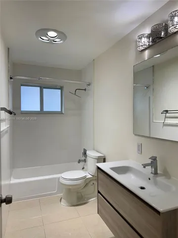 a bathroom with a bathtub shower sink vanity and toilet