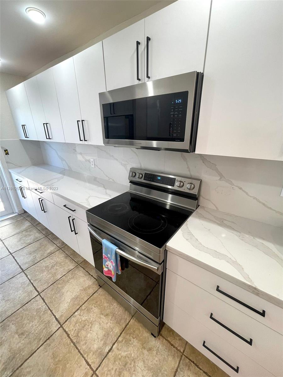 25305 Southwest 124th Court Homestead, FL 33032 - Photo 15 of 39 a kitchen with a stove and a microwave