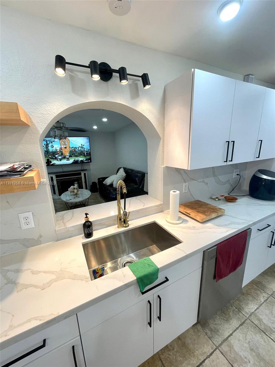 25305 Southwest 124th Court Homestead, FL 33032 - Photo 16 of 39 a kitchen with a sink and a stove with wooden floor