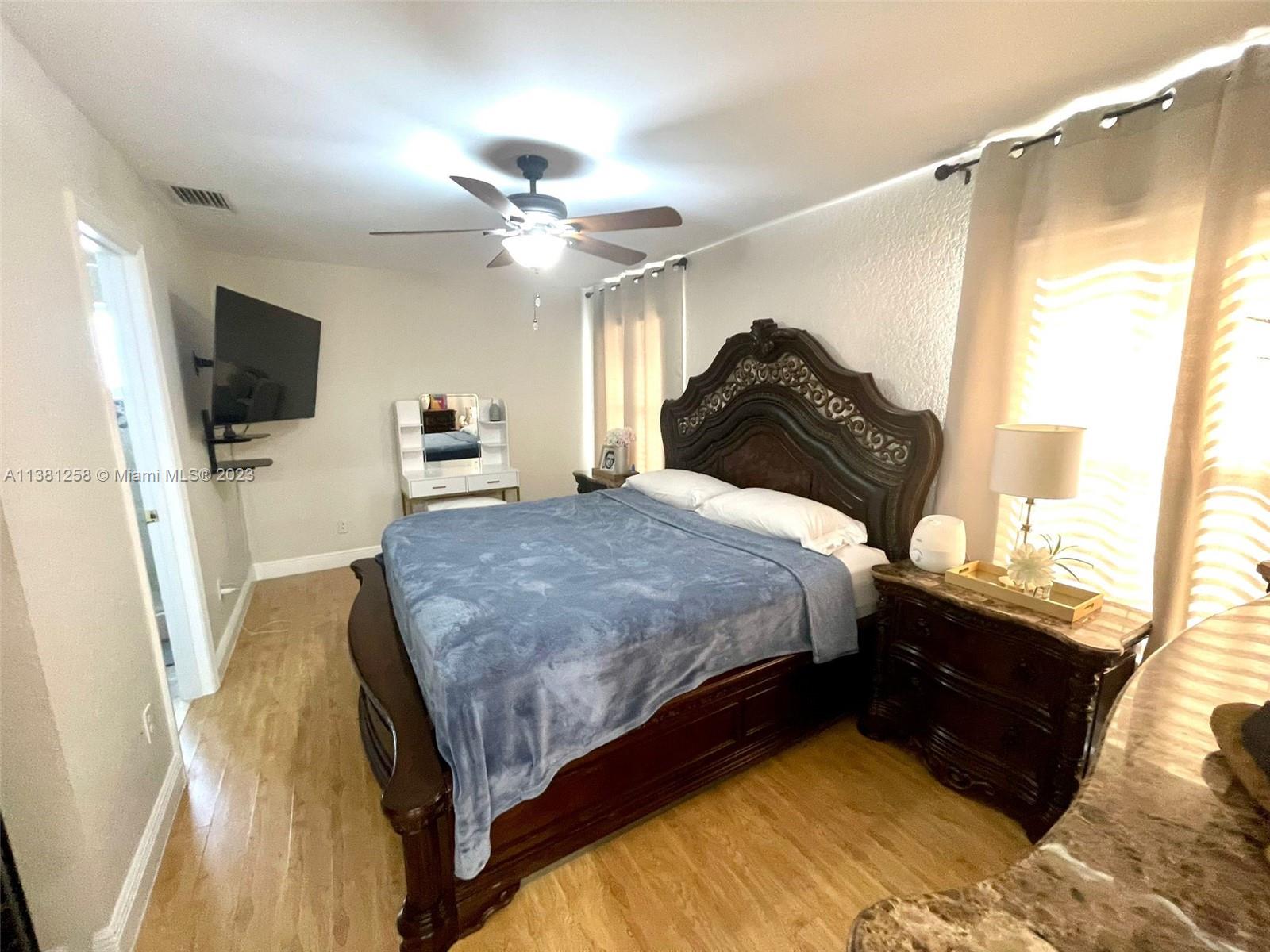 25305 Southwest 124th Court Homestead, FL 33032 - Photo 22 of 39 a spacious bedroom with a bed and a flat screen tv
