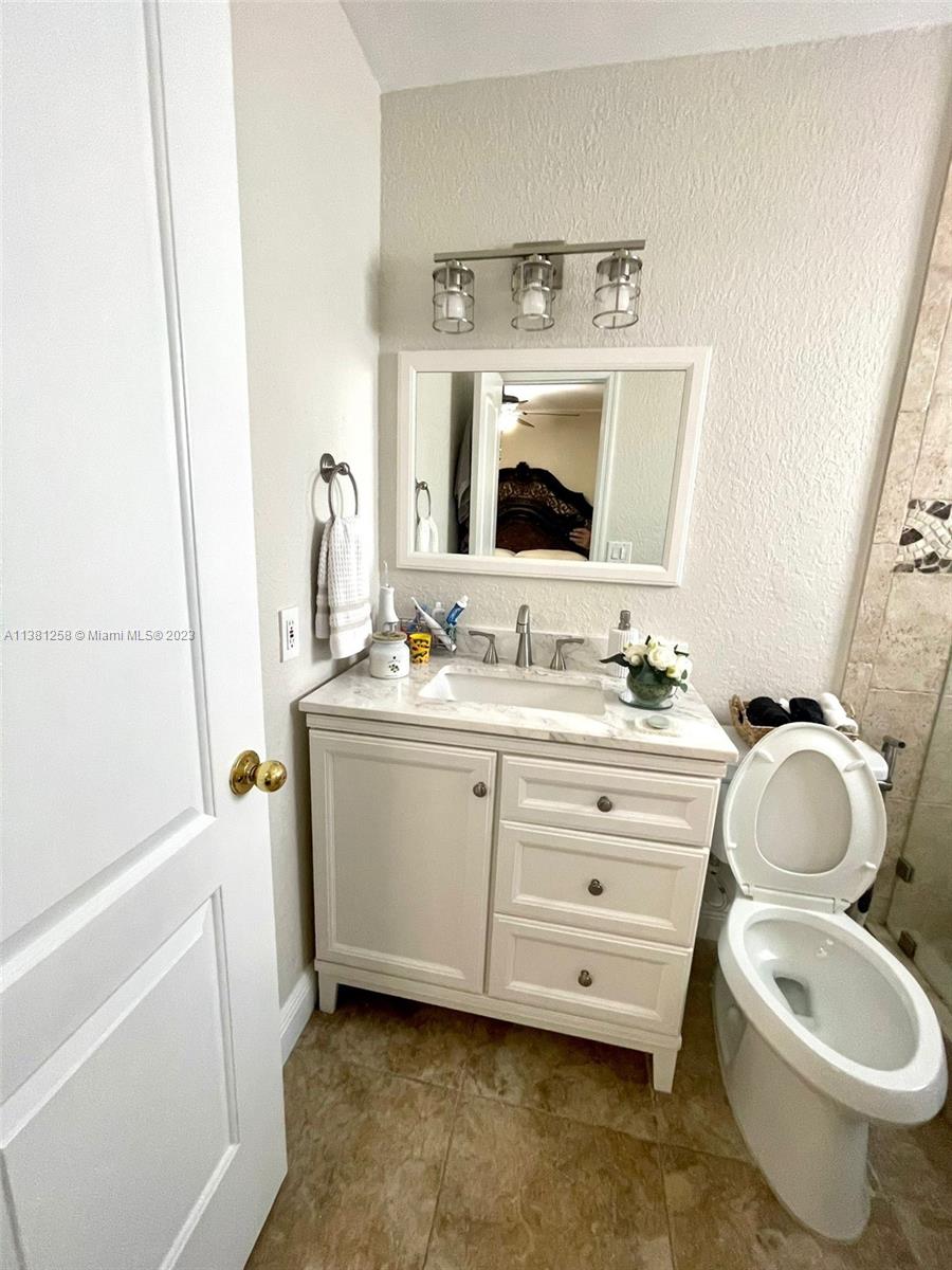 25305 Southwest 124th Court Homestead, FL 33032 - Photo 23 of 39 a bathroom with a toilet sink and mirror
