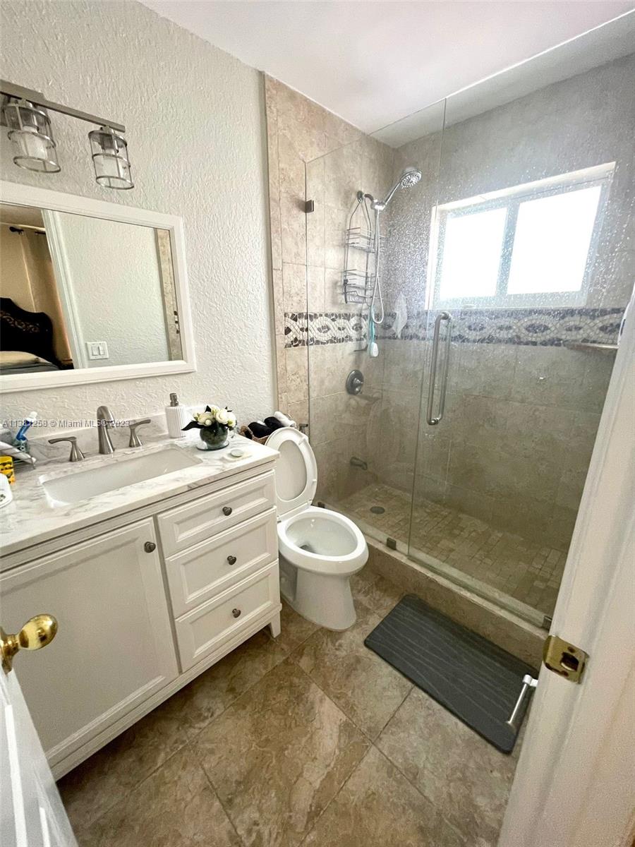 25305 Southwest 124th Court Homestead, FL 33032 - Photo 24 of 39 a bathroom with a granite countertop sink toilet a mirror and shower