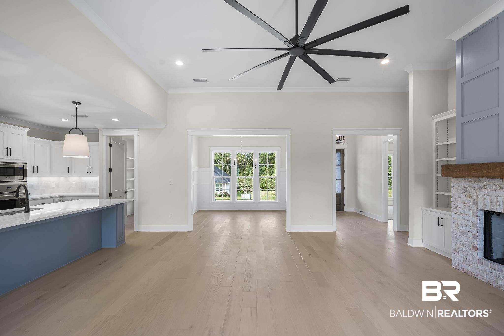 21826 Veranda Boulevard Fairhope, AL 36532 - Photo 7 of 42 Unfurnished living room with crown molding, recessed lighting, light wood-style flooring, built in features, and a stone fireplace