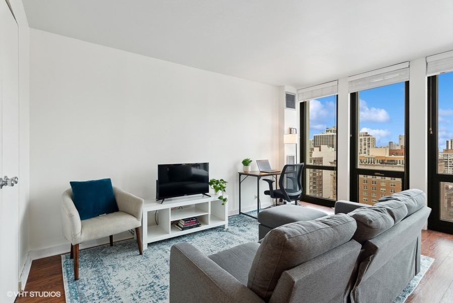 1 East Scott Street, Unit 2011 Chicago, IL 60610 - Photo 6 of 13 a living room with furniture a flat screen tv and a floor to ceiling window