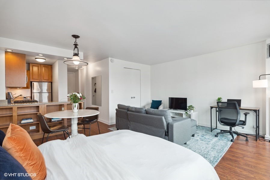 1 East Scott Street, Unit 2011 Chicago, IL 60610 - Photo 8 of 13 a living room with furniture a large window and wooden floor