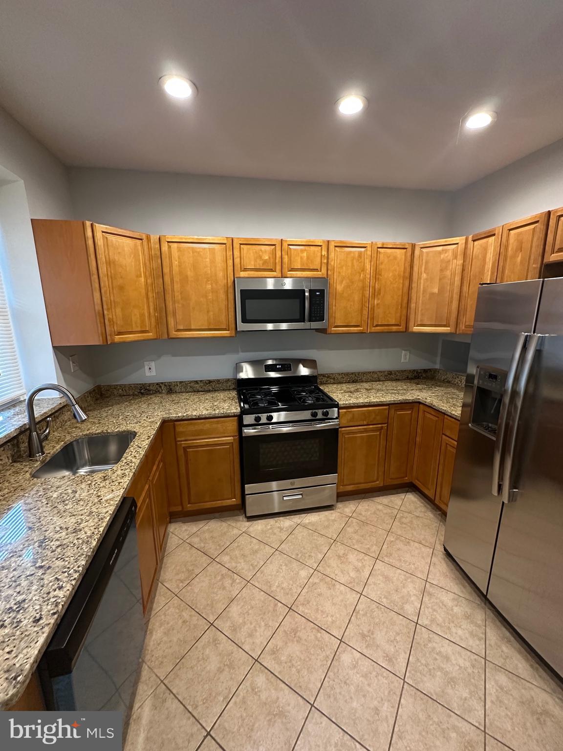 4331 Harford Road, Unit 1 Baltimore, MD 21214 - Photo 3 of 16 a kitchen with stainless steel appliances granite countertop a stove a sink and a microwave