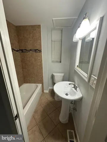 a bathroom with a sink a toilet a mirror and shower
