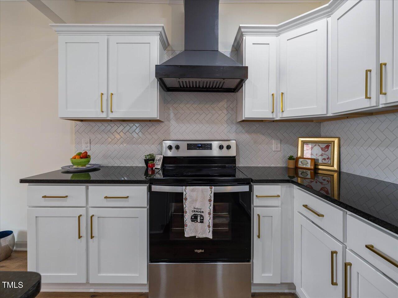 611 Dunbar Street Durham, NC 27701 - Photo 5 of 28 a kitchen with white cabinets and black appliances