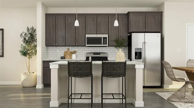 a kitchen with stainless steel appliances kitchen island granite countertop a refrigerator and a stove top oven