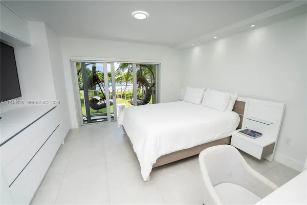 a bedroom with a large bed and a flat screen tv