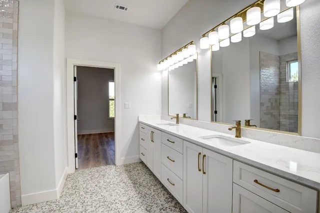 a spacious bathroom with a double vanity sink and a mirror