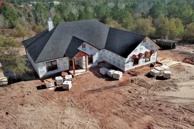a backyard of a house with wooden fence and a couple of chairs