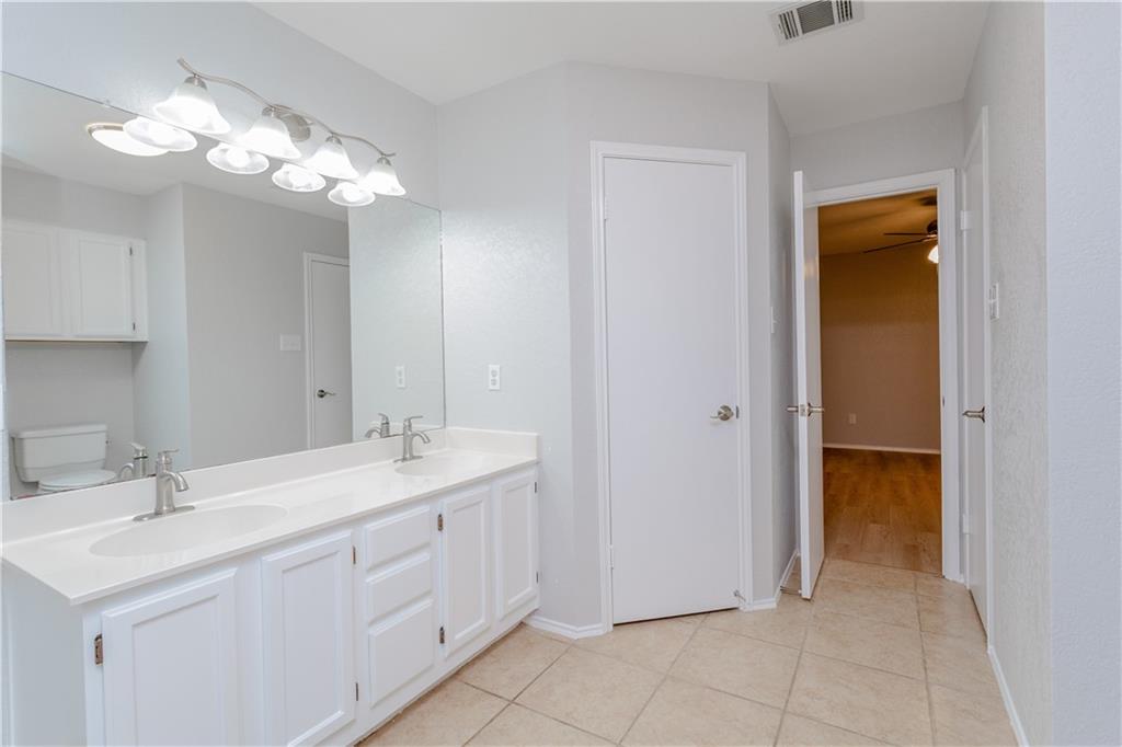 13207 Vendrell Drive Austin, TX 78729 - Photo 14 of 20 a spacious bathroom with a double vanity sink and a mirror