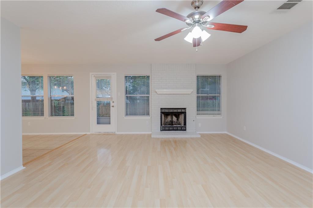 13207 Vendrell Drive Austin, TX 78729 - Photo 4 of 20 an empty room with windows and a fireplace