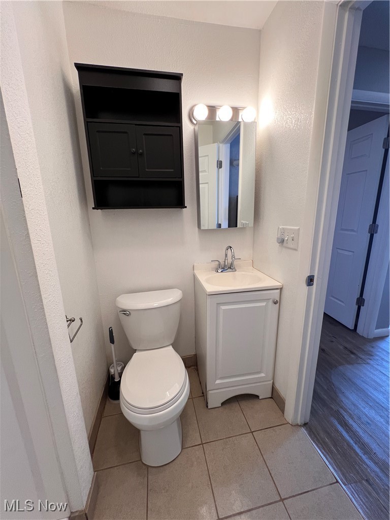 1724 Youngstown Kingsville Road, Unit 4 Vienna, OH 44473 - Photo 9 of 11 Half bathroom featuring toilet, tile patterned flooring, baseboards, and vanity
