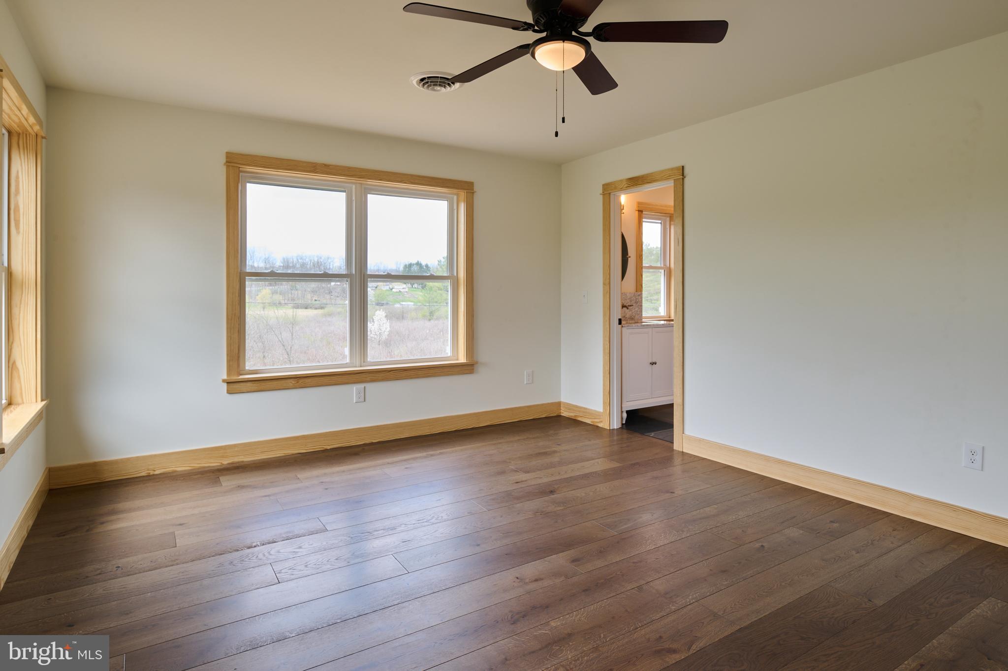 129 Lower Georges Valley Road Spring Mills, PA 16875 - Photo 42 of 61 an empty room with wooden floor chandelier fan and windows