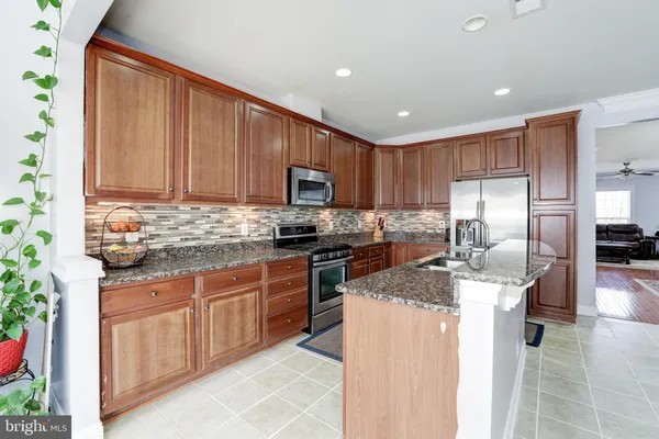 a kitchen with kitchen island granite countertop stainless steel appliances stove microwave and cabinets