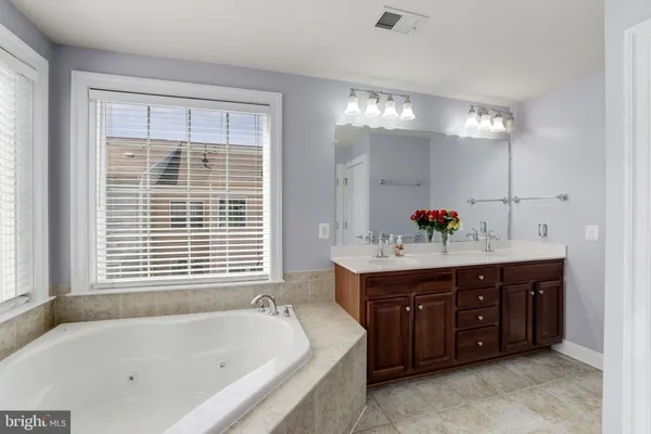 a bathroom with a tub sink and mirror