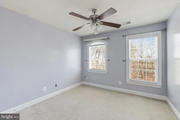 an empty room with a window and a ceiling fan
