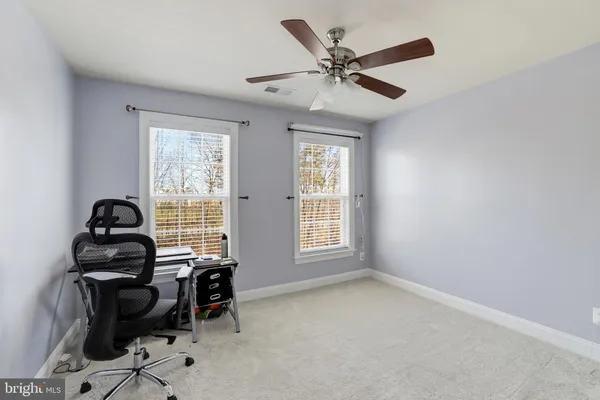 a view of a workspace with furniture and a window