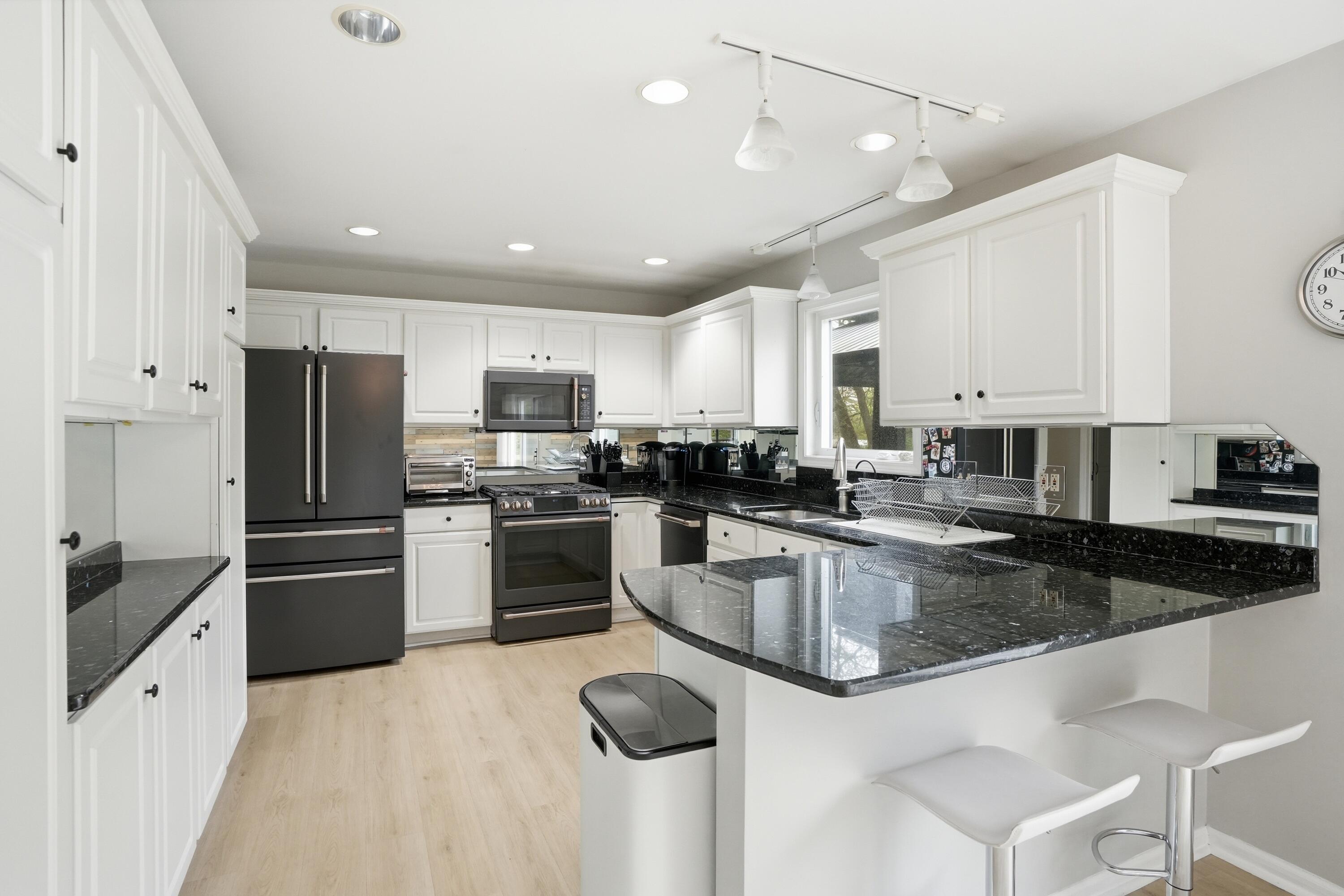 12025 Heron Lake Road St. John, IN 46373 - Photo 12 of 42 a kitchen with granite countertop stainless steel appliances and white cabinets