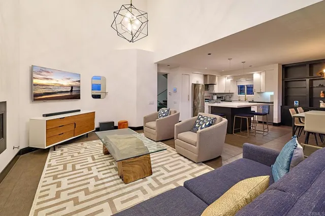 a living room with furniture kitchen view and a flat screen tv