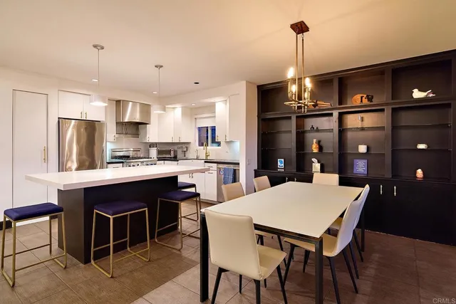 a kitchen with a dining table chairs and refrigerator