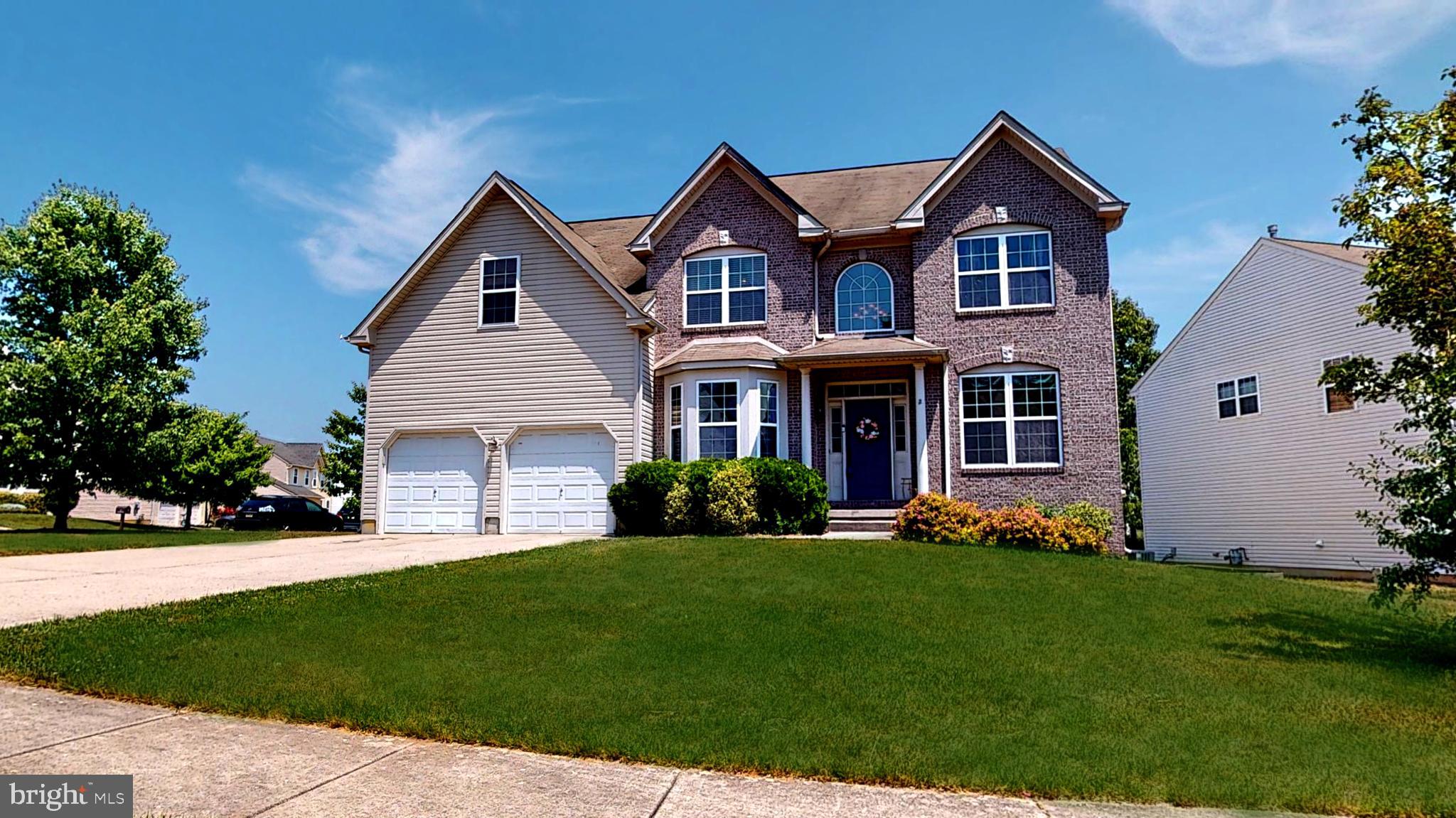 a front view of a house with a garden and yard