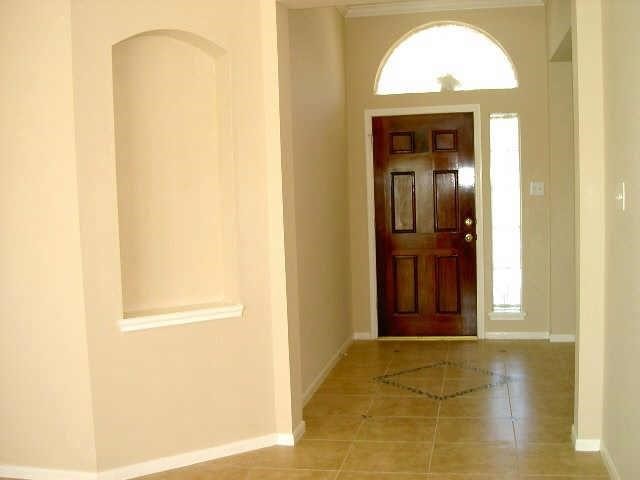 4542 Springfield Lakes Street Sugar Land, TX 77479 - Photo 2 of 16 Grand foyer entry with decorative front door, arched architectural details, and tile flooring.