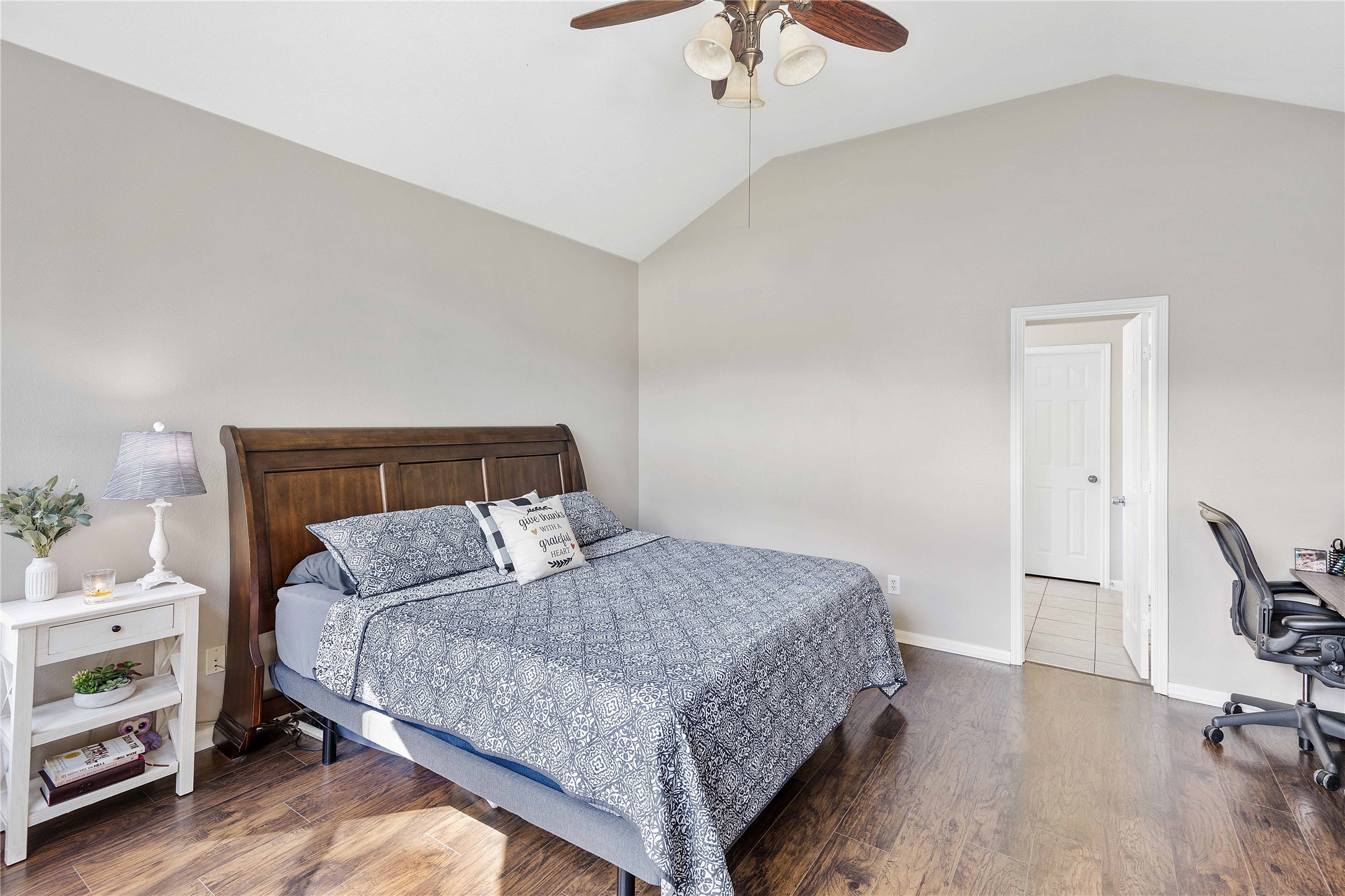 24506 Fort Path Drive Spring, TX 77373 - Photo 21 of 46 Spacious bedroom with vaulted ceilings, featuring a cozy bed, elegant wood plank floors, and ample natural light.