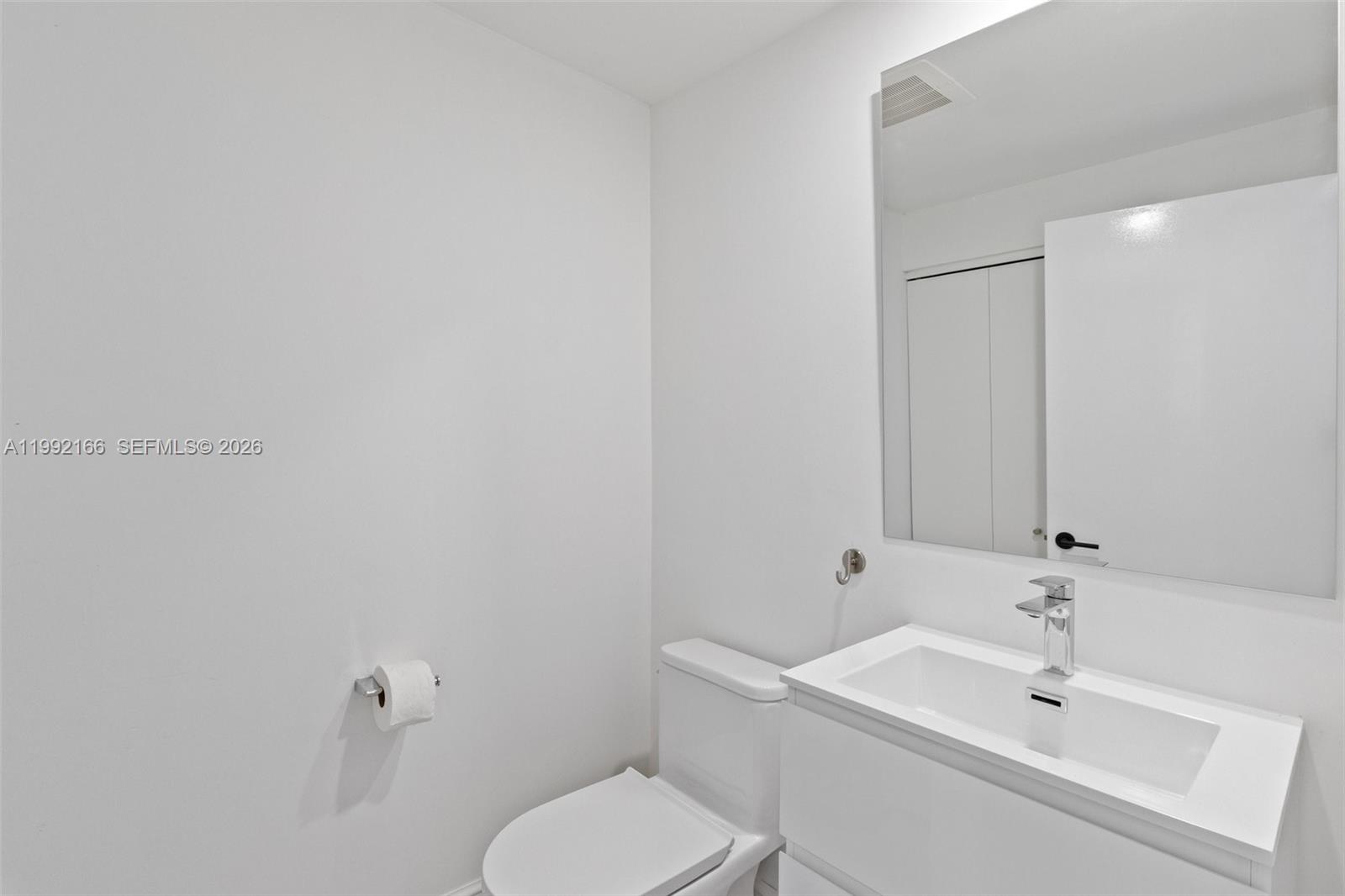 901 Brickell Key Boulevard, Unit 1609 Miami, FL 33131 - Photo 15 of 35 a bathroom with a toilet a sink and mirror