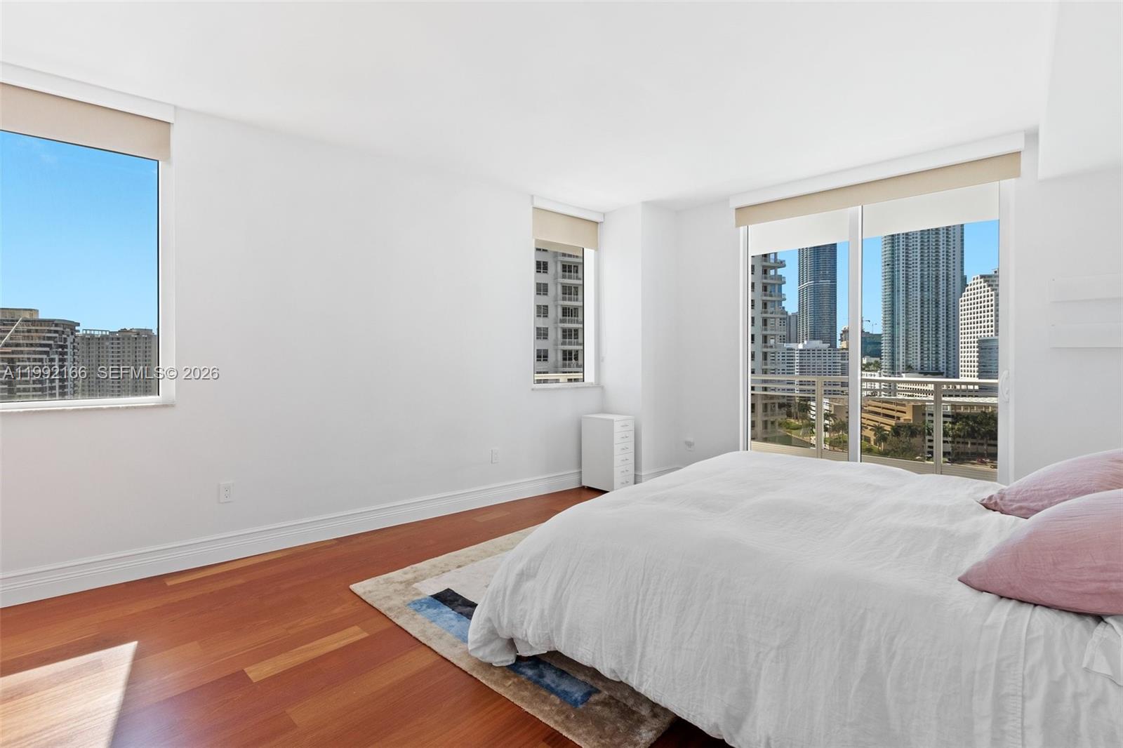 901 Brickell Key Boulevard, Unit 1609 Miami, FL 33131 - Photo 16 of 35 a large bed sitting in a bedroom next to a window
