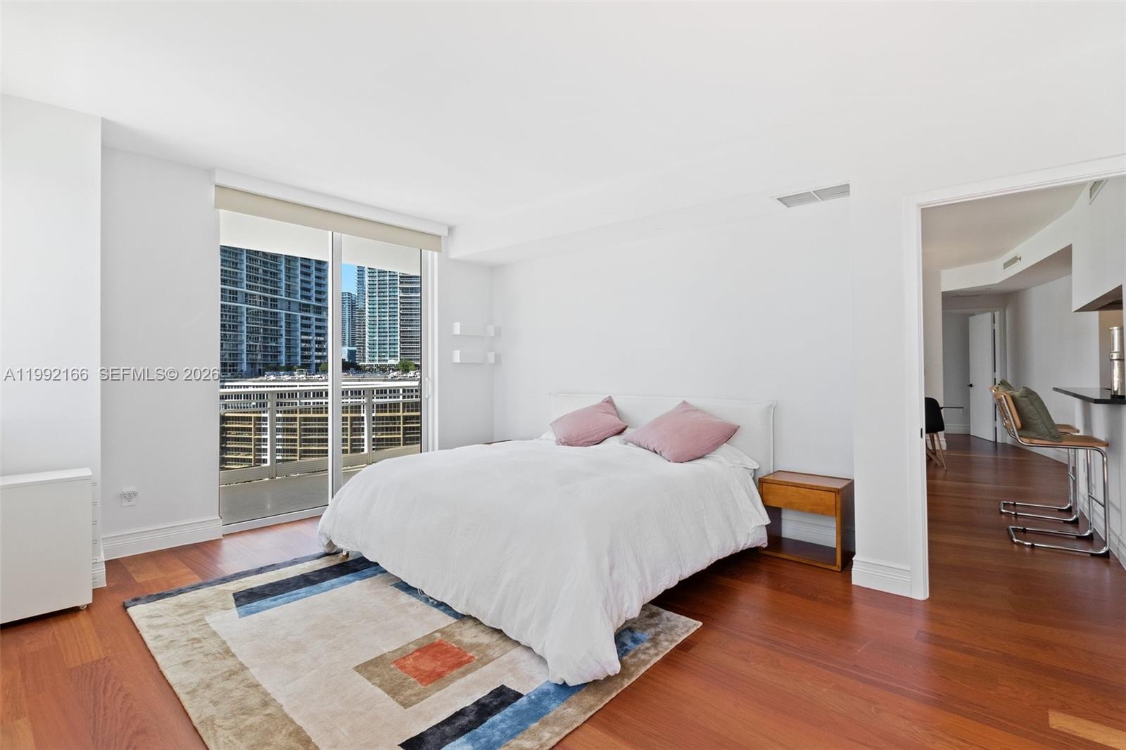 901 Brickell Key Boulevard, Unit 1609 Miami, FL 33131 - Photo 17 of 35 a bedroom with a bed and wooden floor