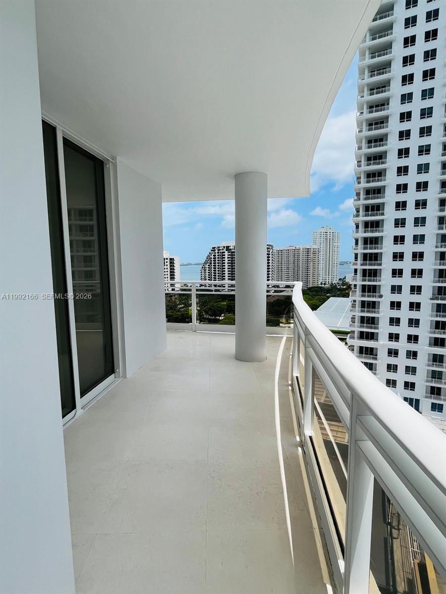 901 Brickell Key Boulevard, Unit 1609 Miami, FL 33131 - Photo 19 of 35 a kitchen with a refrigerator and white cabinets