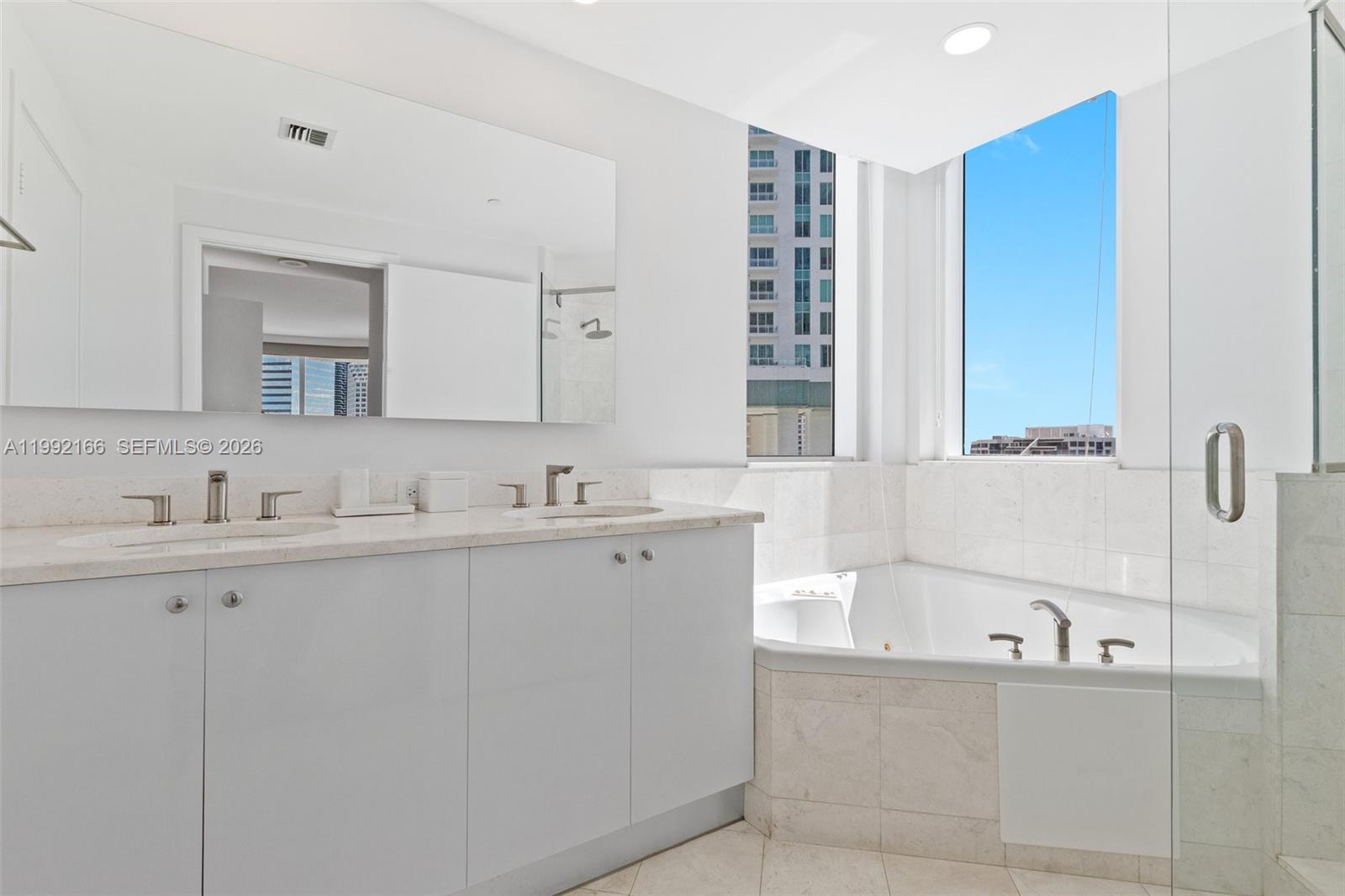 901 Brickell Key Boulevard, Unit 1609 Miami, FL 33131 - Photo 20 of 35 a bathroom with a tub sink and mirror
