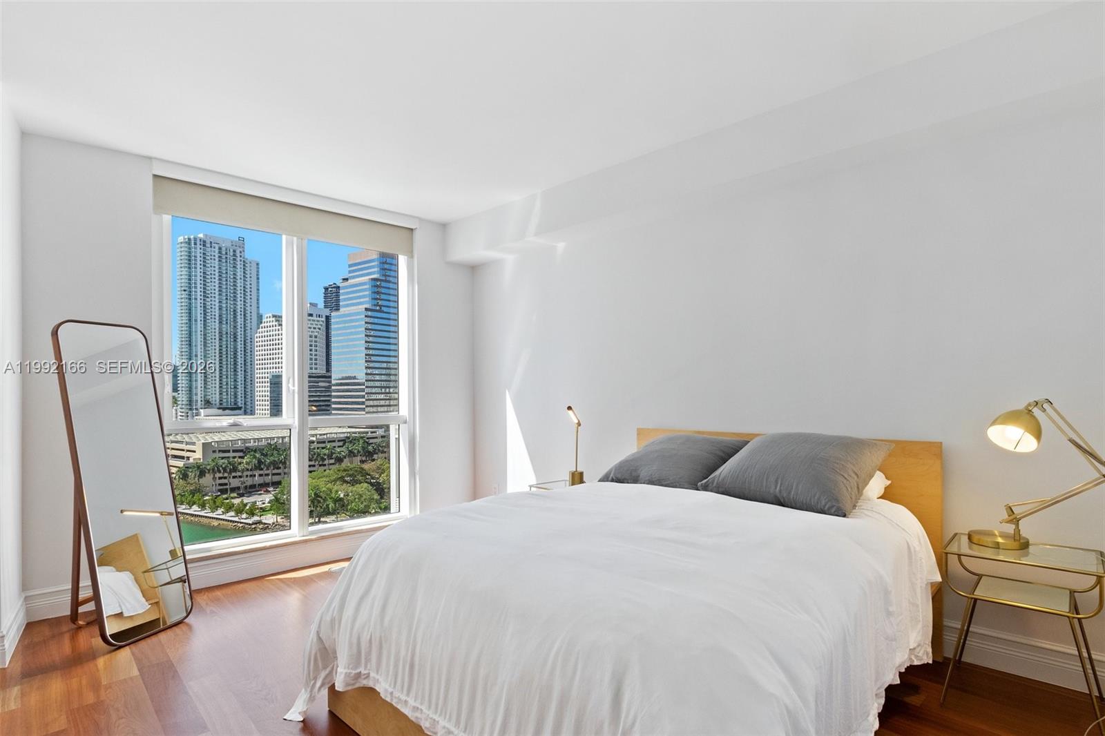 901 Brickell Key Boulevard, Unit 1609 Miami, FL 33131 - Photo 22 of 35 a bedroom with a bed and wooden floor