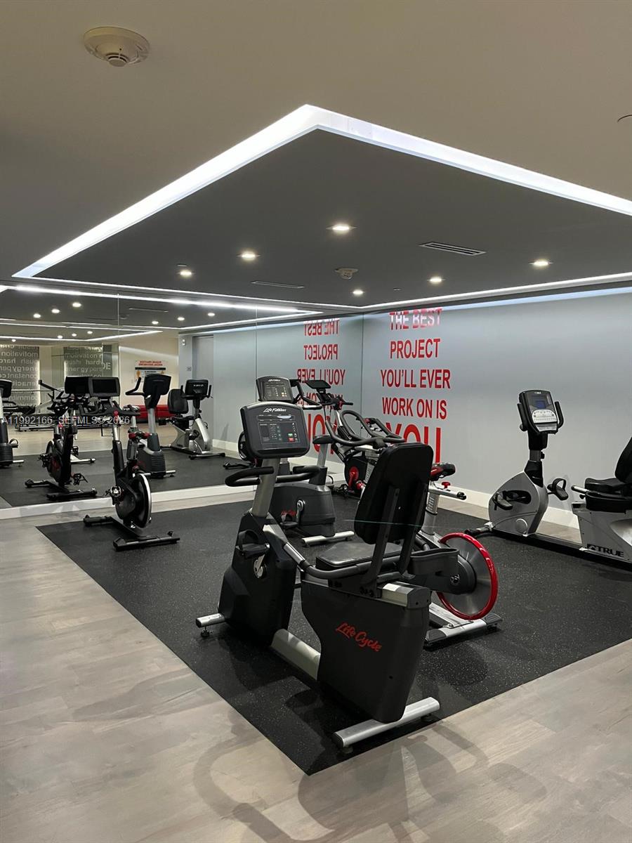 901 Brickell Key Boulevard, Unit 1609 Miami, FL 33131 - Photo 30 of 35 a room with gym equipment and a large window