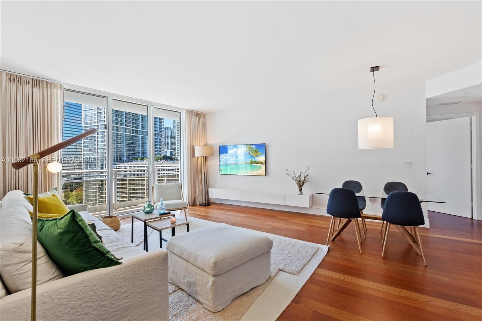 901 Brickell Key Boulevard, Unit 1609 Miami, FL 33131 - Photo 4 of 35 a living room with furniture and wooden floor