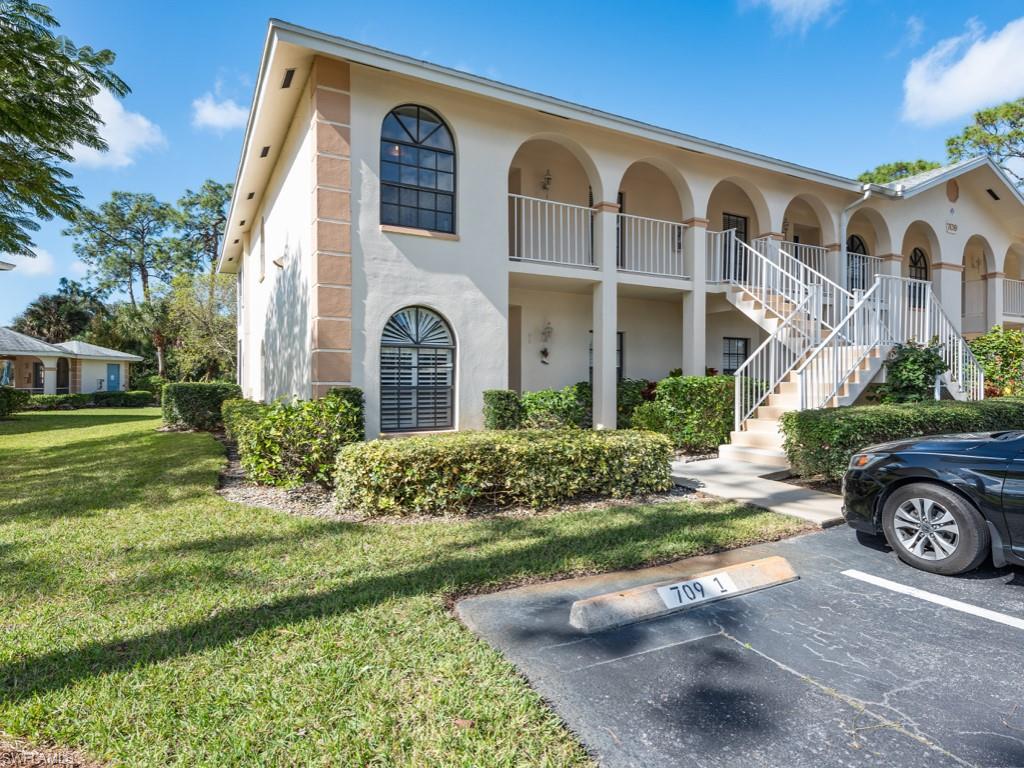 709 Augusta Boulevard, Unit 7095 Naples, FL 34113 - Photo 15 of 16 a front view of a house with a yard